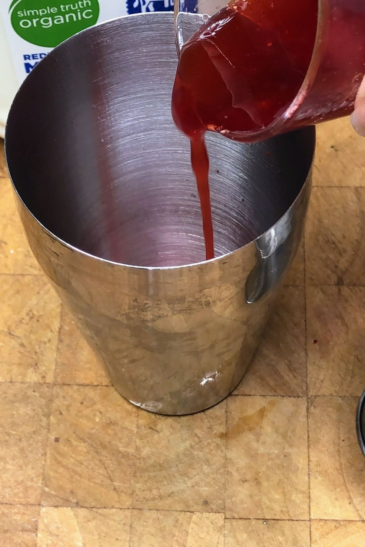 Pouring simple syrup into a shaker.
