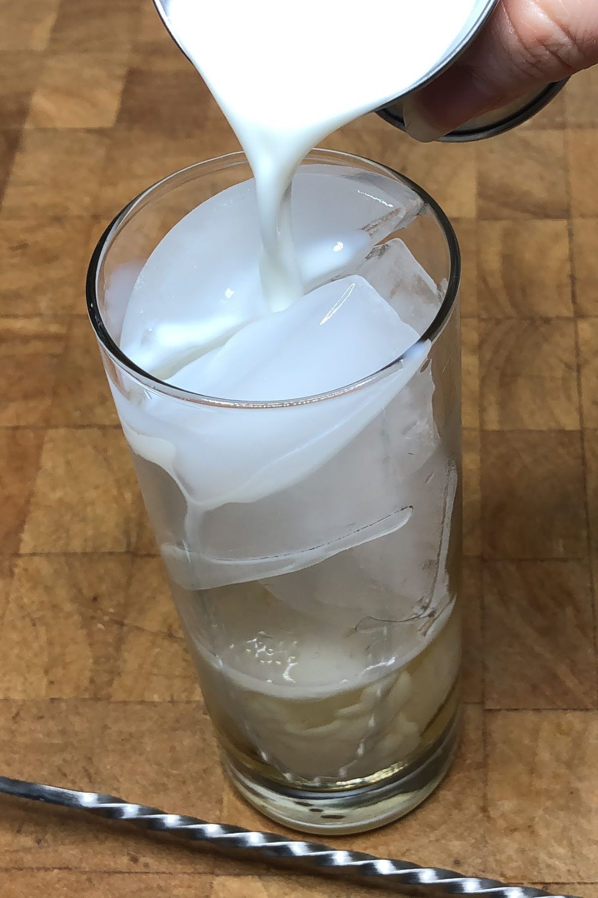 Pouring milk into a highball glass.