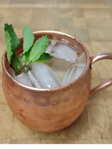 Tennessee mule on a wooden table with mint in the mug.