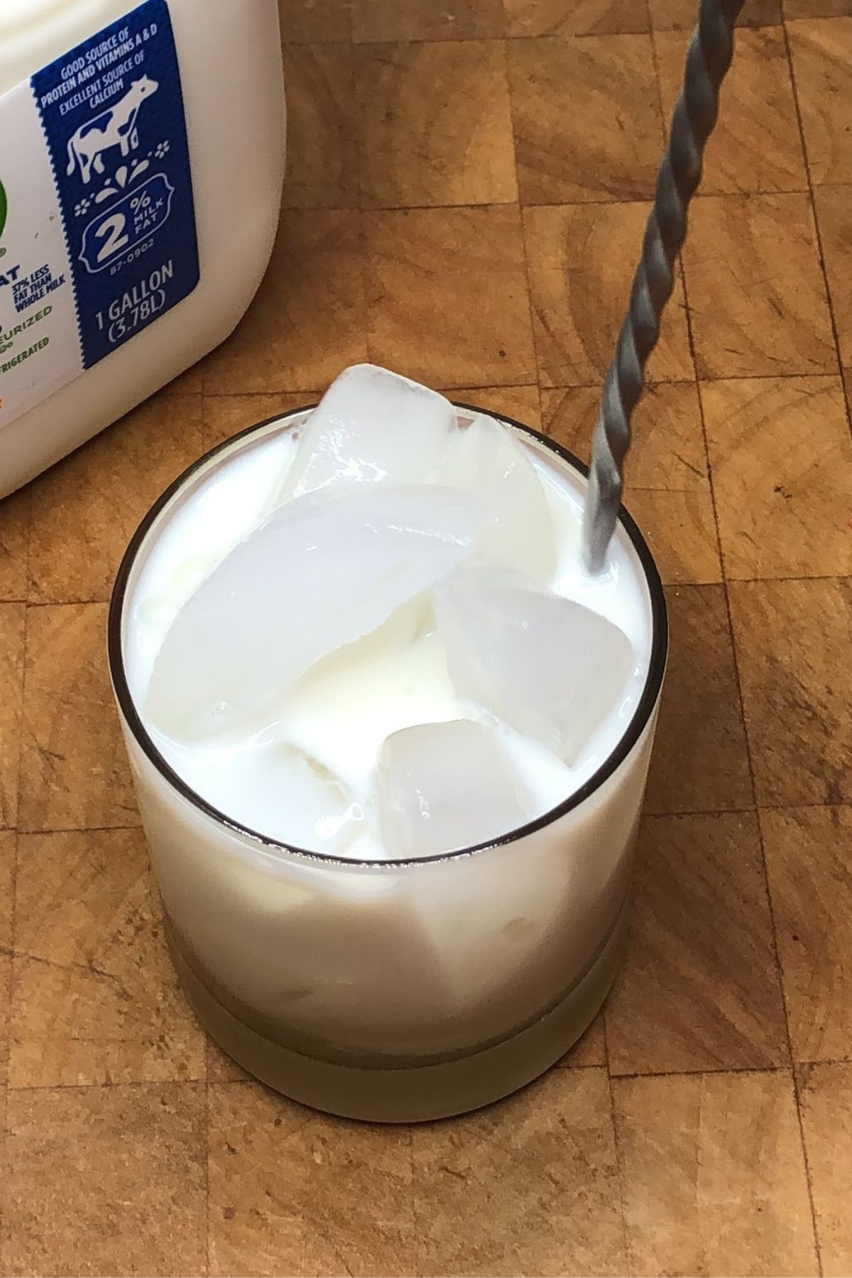 Stirring vanilla milk with a bar spoon.