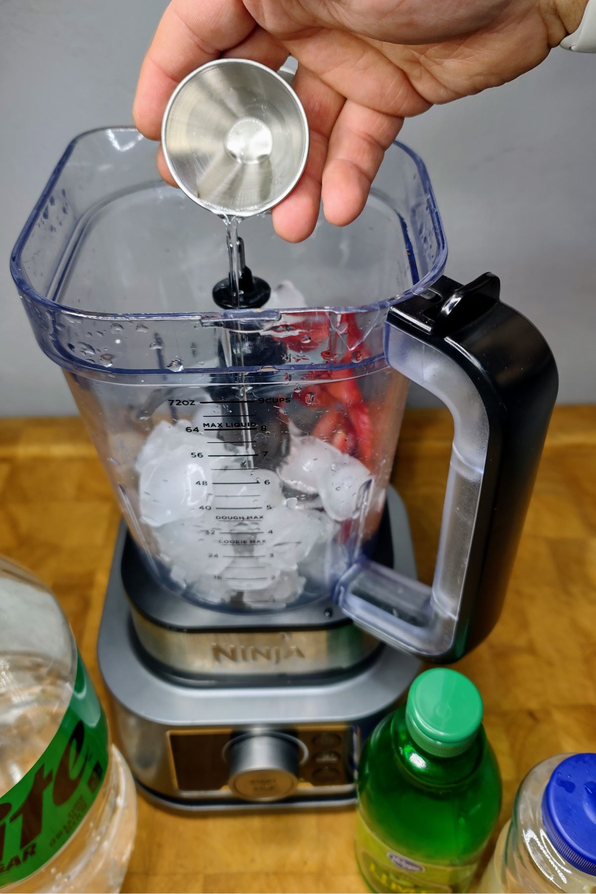 Pouring simple syrup into a blender.