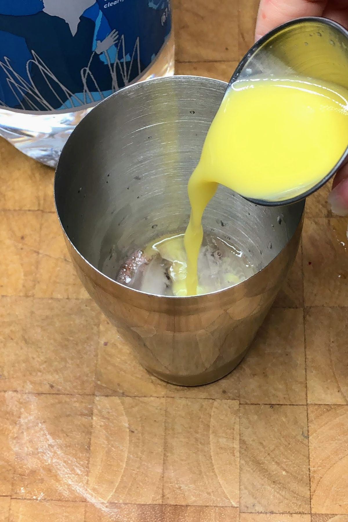 Pouring orange juice into a shaker.