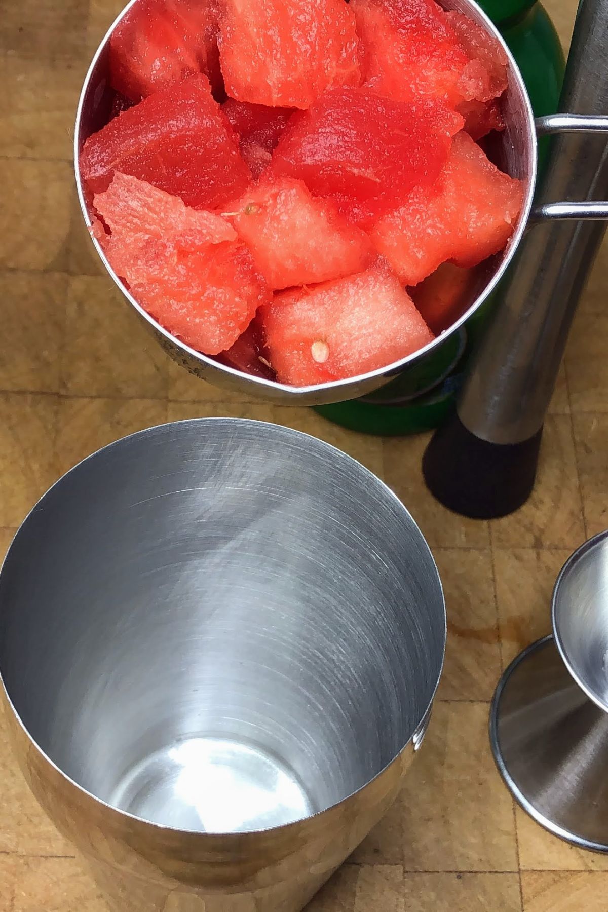 Dumping watermelon chunks into a shaker.