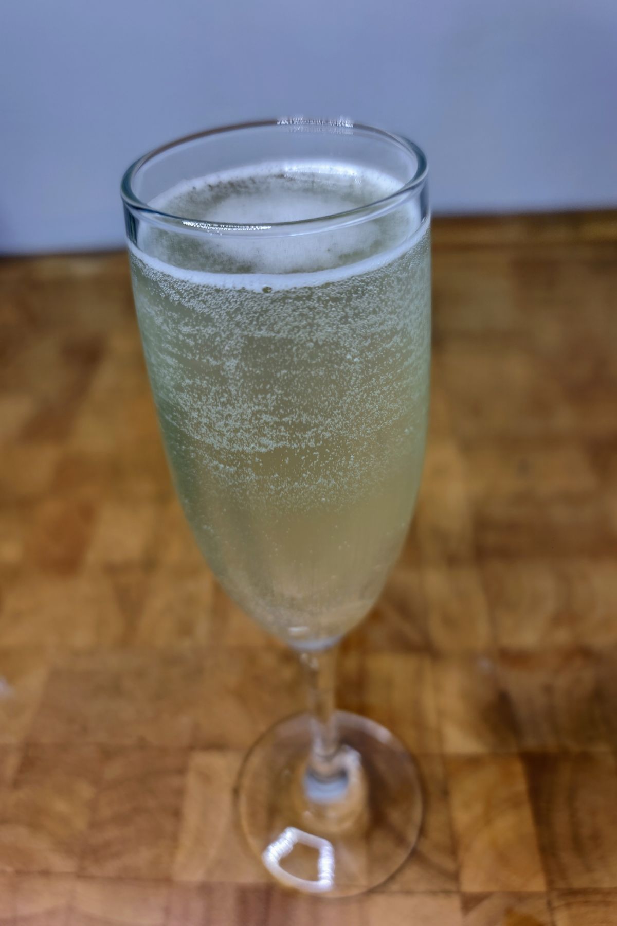 French 75 cocktail on a wooden table.