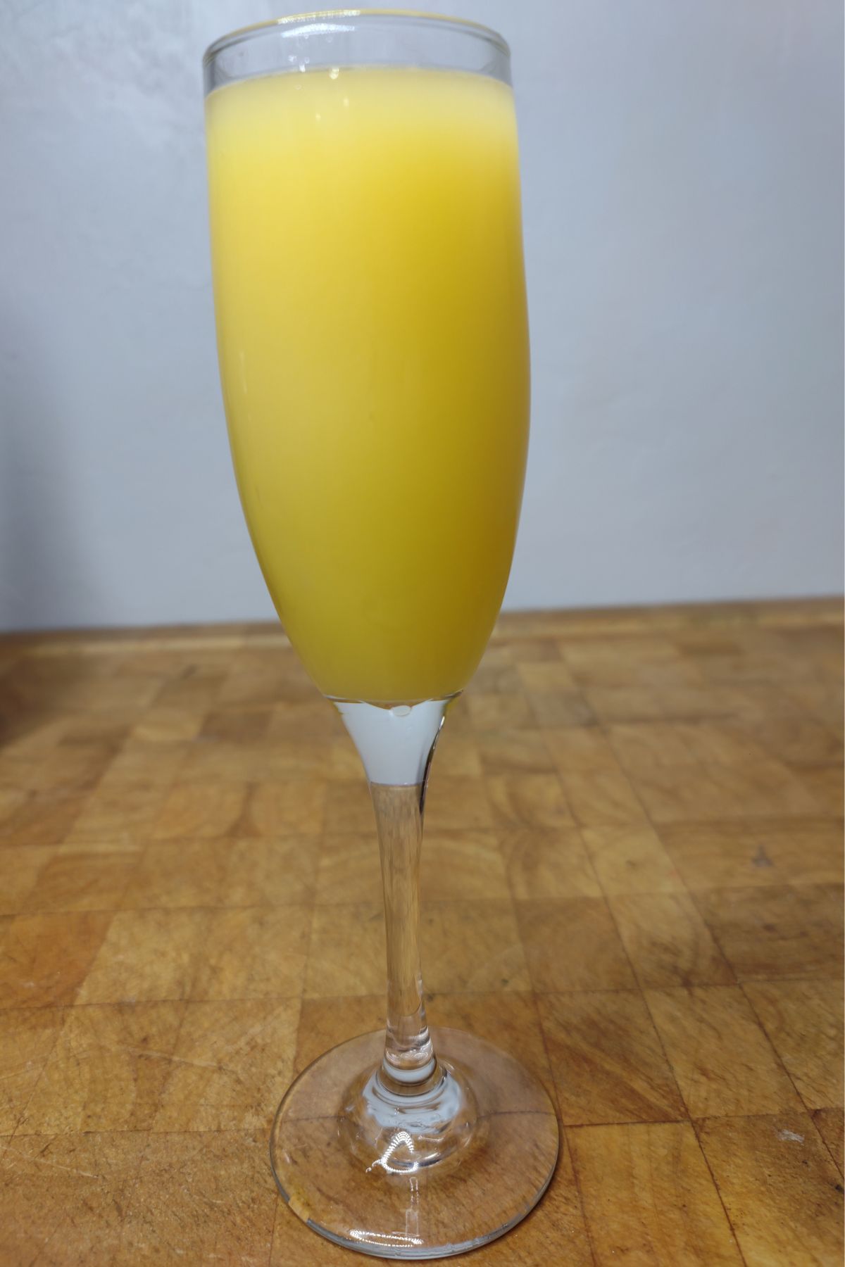 Orange creamsicle mimosa on a wooden table.