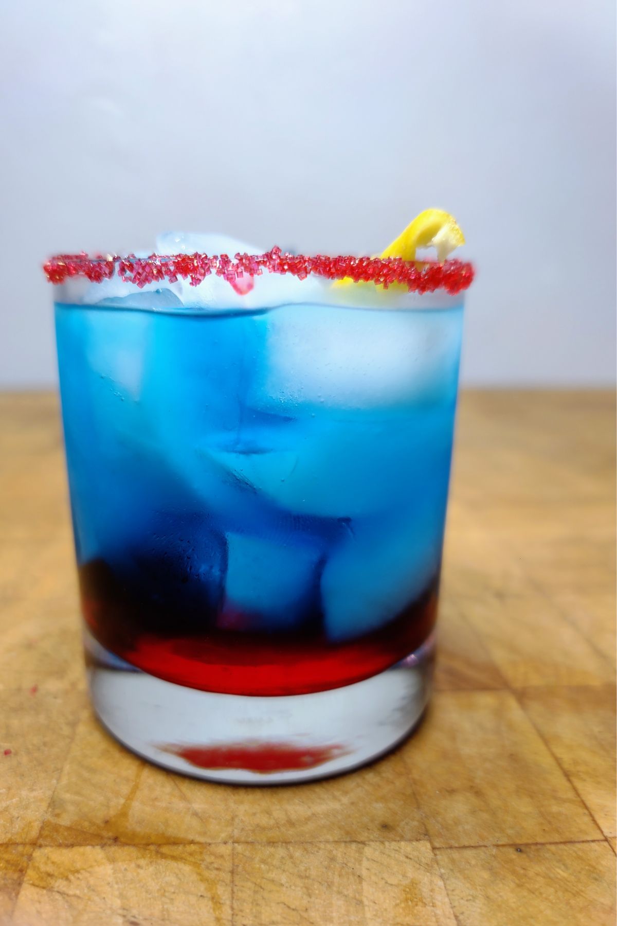 Superman cocktail on a wooden table.