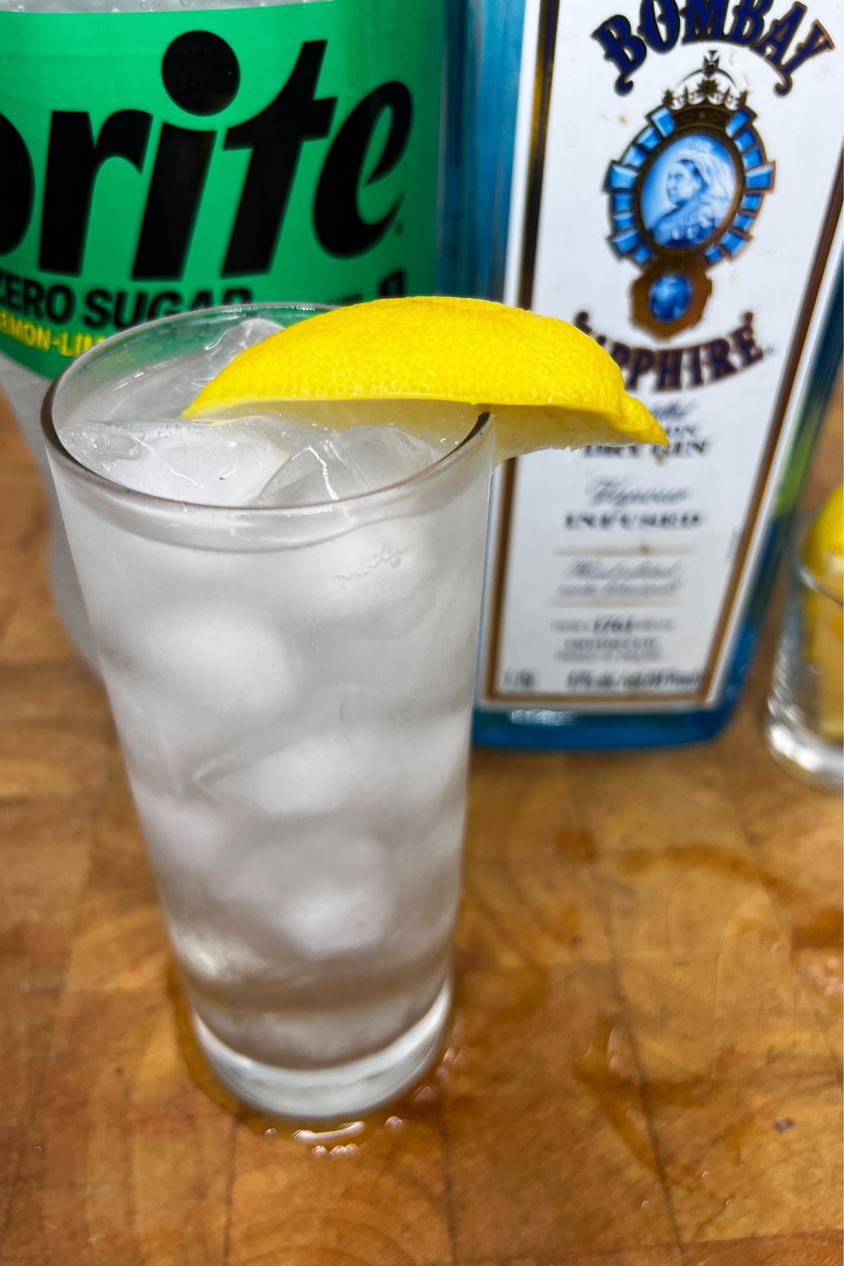 Adding a lemon wedge to a gin and sprite.