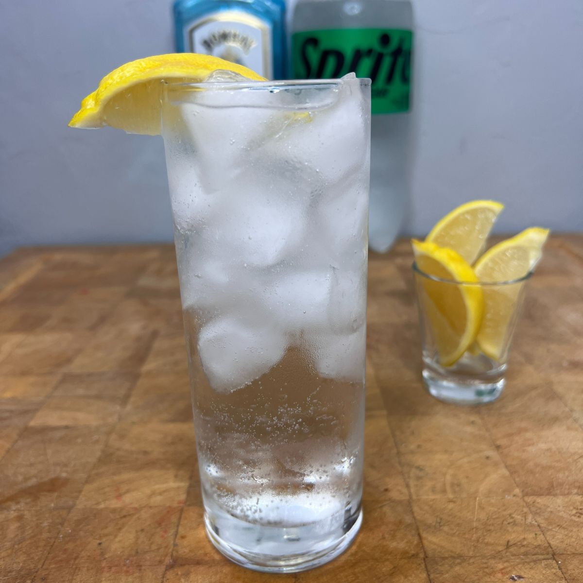 Close up of a gin and sprite with a lemon wedge on the rim.
