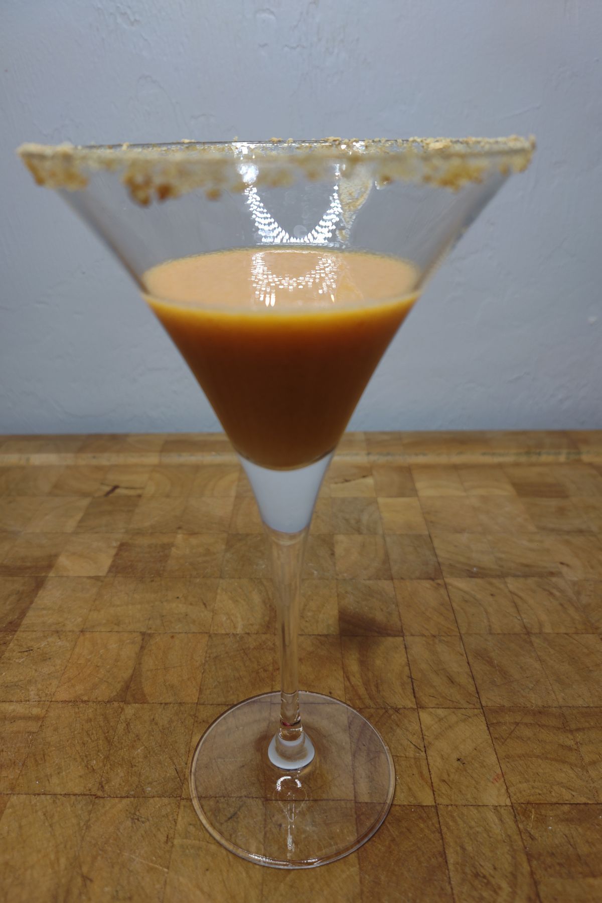 Pumpkin pie martini on a wooden table.